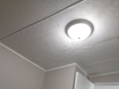 After: the ceiling redrywalled, retextured and painted, with the fixture reset.